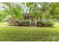 Charming brick home featuring a welcoming front porch and lush, green landscaping at 302 6Th Sw St, Conover, NC 28613