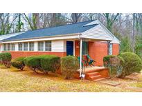 Charming brick home with a cozy front porch and manicured bushes in a well-maintained yard at 3232 Marlborough Rd, Charlotte, NC 28208