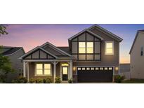 Charming two-story home showcasing craftsman architecture, dark trim, two-car garage, and manicured landscaping at 3252 Cheyney Park Dr, Charlotte, NC 28269