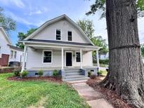 Charming two-story home featuring a cozy front porch and meticulously landscaped front yard with a beautiful large shade tree at 419 S Spencer Ave, Spencer, NC 28159