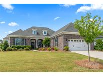 Charming brick home with a well-manicured lawn, beautiful landscaping, and a two-car garage at 45523 Misty Bluff Dr, Charlotte, NC 28278