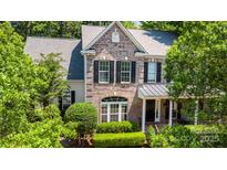 Charming brick two-story home featuring classic black shutters and manicured landscaping at 6729 Garden Hill Dr, Huntersville, NC 28078