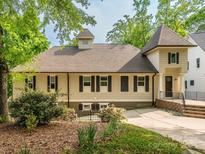 Charming home featuring light siding, dark shutters, and mature landscaping in a tranquil setting at 7324 Leharne Dr, Charlotte, NC 28270