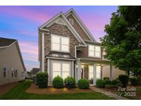 Charming two-story home featuring stone accents, covered front porch, and manicured landscaping at 1004 Craven St, Indian Trail, NC 28079