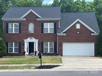 Traditional two-story brick home with a well-manicured lawn and a two-car garage at 12244 Wallace Ridge Dr, Charlotte, NC 28269