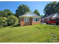 Charming single-story brick home with a well-maintained lawn, mature trees, and sunny blue skies at 124 10Th Sw St, Conover, NC 28613