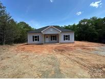 Charming single-story home featuring gray siding, a gable roof, and a welcoming front porch in a serene wooded setting at 1247 Beltline Rd # 1, Chester, SC 29706