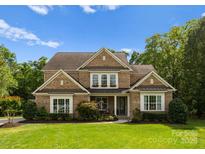Charming brick home with manicured lawn, lush landscaping, and a welcoming front porch at 1410 Smoketree Ct, Waxhaw, NC 28173