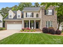 Charming two-story home with brick and siding, manicured lawn, and inviting front porch at 14849 Middlesborough Dr, Matthews, NC 28104