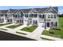 New townhomes feature colorful doors, black shutters, garages, and attractive landscaping at 153 Jameson Park Dr # 4, Troutman, NC 28166