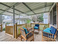 Inviting covered porch with wooden furniture and blue cushions, perfect for relaxing outdoors at 201-A Ewing Dr, Belmont, NC 28012