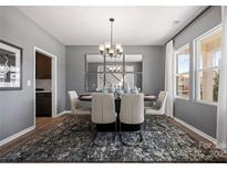 Contemporary dining room features a modern chandelier, a mirrored wall, and a stylish rug under the dining table at 2010 Puddle Pond Rd, Indian Trail, NC 28079