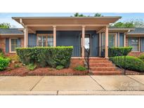 Inviting blue home featuring a brick-lined front entrance, stylish columns, and manicured landscaping at 212 Pointe Cir, Rock Hill, SC 29732