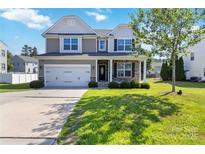 Charming two-story home with a well-manicured lawn, attached garage, and inviting front porch at 217 Hydrangea Dr, Clover, SC 29710