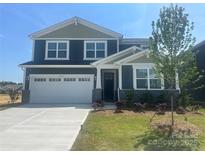 Two-story home featuring a two-car garage, manicured lawn, and pleasant landscaping at 2635 Tillman St, Monroe, NC 28112