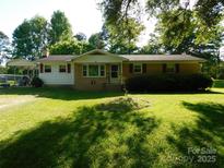 Ranch-style home with a well-manicured lawn, mature trees, and a covered carport at 2826 Drew Dr, Lancaster, SC 29720