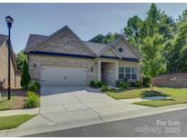 Charming single-Gathering home with a well-manicured front yard and a two-car garage at 3002 Portico Pl, Tega Cay, SC 29708
