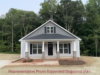Charming home featuring a covered front porch, gray siding, and a welcoming entrance at 404 N Peterson St, Stanley, NC 28164