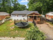 View of the home's backyard with a trampoline and wooden porch, fenced in for outdoor enjoyment at 430 Edgegreen Dr, Charlotte, NC 28217