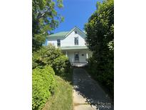 Charming two-story home with a metal roof and mature trees in a lush yard at 723 Pee Dee Ave, Albemarle, NC 28001