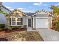 Charming single-story home featuring gray siding, a one-car garage, and a well-maintained front yard at 7616 Monarch Birch Ln, Charlotte, NC 28215