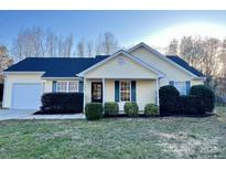 Charming single-story home with yellow siding, blue shutters, and a well-manicured front lawn at 8809 Reedy Creek Rd, Charlotte, NC 28215