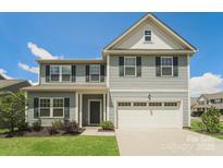 Charming two-story home with blue siding, a two-car garage and well-maintained landscaping at 9127 Colwick Hill Ln, Charlotte, NC 28215