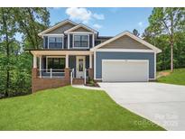Charming two-story home with blue siding, a two-car garage, and a welcoming front porch at 1118 Allman Ext, Mount Pleasant, NC 28124