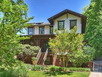 Beautiful home exterior featuring a brick base, landscaped yard, and inviting wooden steps to the front door at 1413 Devon Dr, Charlotte, NC 28209