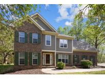 Charming brick and siding home with green shutters and manicured landscaping, front yard at 15324 Yarmouth Rd, Mint Hill, NC 28227