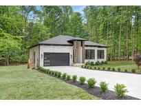 Charming home with neutral colored brick, manicured lawn and sleek black garage door at 1534 Easy St, Belmont, NC 28012