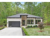 Stunning modern home boasts a white brick facade, black trim, and an attached garage at 1534 Easy St, Belmont, NC 28012