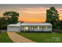 Charming home with a welcoming front porch, well-manicured lawn, and attached garage at 2054 Hickory Hills Dr, Denver, NC 28037