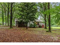 Charming single-story home with a screened porch, surrounded by mature trees and lush landscaping at 6804 Lineberger Rd, Denver, NC 28037