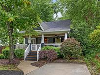 Charming home featuring a welcoming porch, manicured landscaping, and a blend of natural beauty and curb appeal at 716 Ellsworth Rd, Charlotte, NC 28211