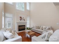 Bright living room with a fireplace, shuttered windows, and comfortable seating at 7722 Springs Village Ln # 40, Charlotte, NC 28226
