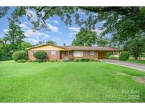 Charming brick ranch-style home featuring a well-maintained lawn and a convenient carport at 812 Clinton Ave, Lancaster, SC 29720