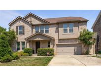 Charming two-story brick home featuring a two-car garage and professionally landscaped front yard at 8614 Goodman Park Ct, Charlotte, NC 28277