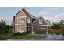 Charming two-story home featuring stone accents, gray siding, a two-car garage, and a well-maintained front yard at Lot 2 Henderson Cir, Harrisburg, NC 28075