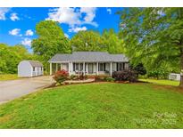 Charming single-story home with a welcoming front porch and colorful landscaping at 1013 E Academy St, Cherryville, NC 28021