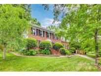 Charming brick home with lush landscaping, inviting stairs, and classic architectural details at 1023 Evian Ln, Matthews, NC 28105