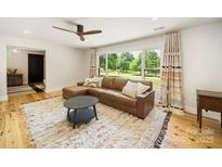 Inviting living room features a cozy sectional sofa, decorative pillows, and a large window with picturesque outdoor views at 1207 Carlson Dr, Monroe, NC 28110