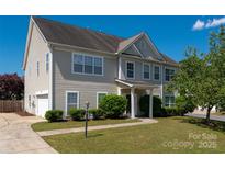 Charming two-story home with well-maintained lawn and lush landscaping offers great curb appeal at 12802 Waterlyn Club Dr, Charlotte, NC 28278