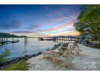 Inviting beachfront with lounge chairs and tranquil waters at sunset at 17819 John Connor Rd, Cornelius, NC 28031