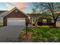 Charming single-story home featuring a brick facade, well-manicured lawn and attached garage with carriage door at 202 Pond View Dr, Salisbury, NC 28147