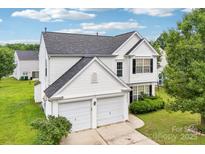 Charming two-story home with a two-car garage, manicured lawn, and beautiful landscaping at 3038 Old Ironside Dr, Charlotte, NC 28213