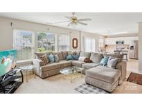 Bright living room features a large sectional sofa, multiple windows and open floor plan at 3038 Old Ironside Dr, Charlotte, NC 28213