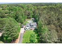 Stunning aerial view of the white house with lush green landscaping, pool, and surrounding forest at 317 Marietta Rd, Mooresville, NC 28117