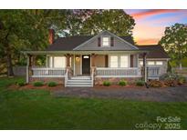 Charming home with a welcoming front porch and well-maintained landscaping at 319 N Central Ave, Locust, NC 28097