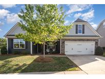 Charming home featuring gray siding, stone accents, manicured lawn, and a two-car garage at 3267 Lock Erne Ave, Kannapolis, NC 28081